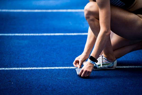 Eine Staffellaeuferin markiert den Anlaufpunkt waehrend der deutschen Leichtathletik-Meisterschaften im Olympiastadion am 26.06.2022 in Berlin